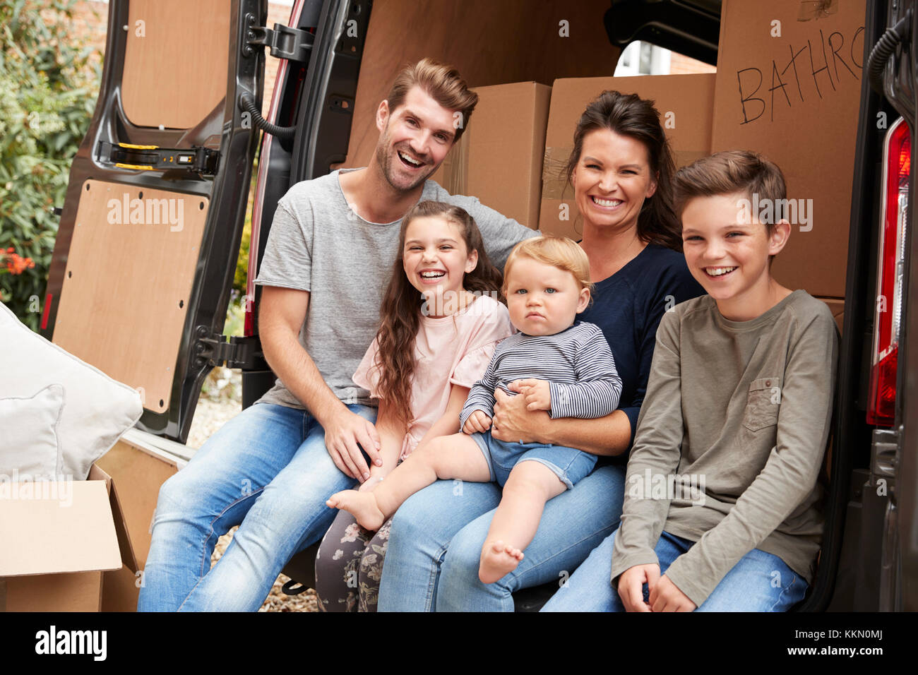 Family Sitting in arrière de camion de déménagement le jour du déménagement Banque D'Images