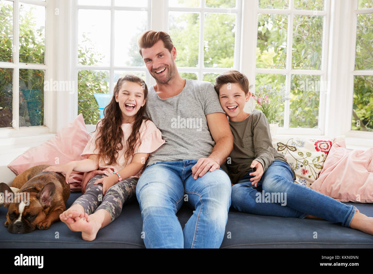 Livre de lecture père avec enfants et chien de compagnie à la maison Banque D'Images