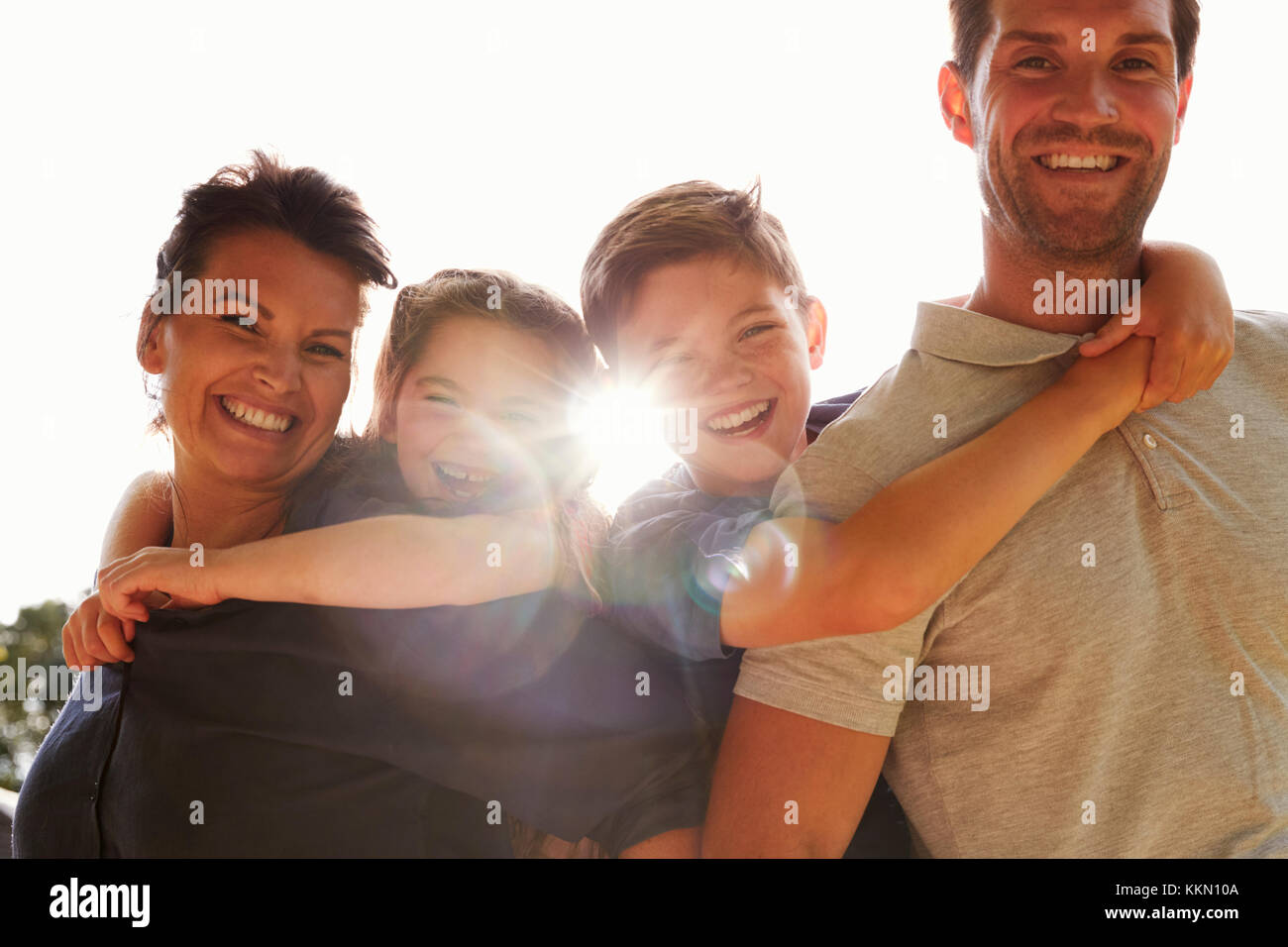 Portrait d'enfants Les parents qui s'y greffent en jardin Banque D'Images