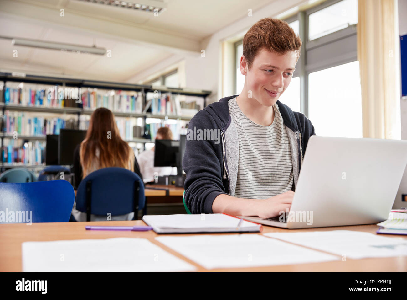 Male Student Working at Laptop in College Library Banque D'Images