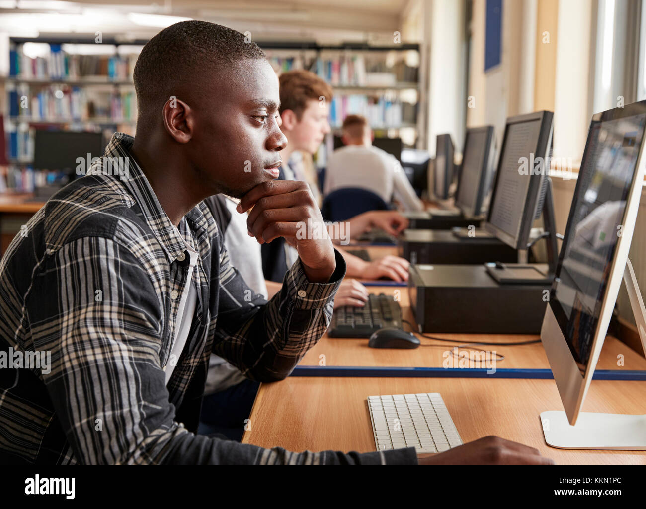 Male Student working on Computer in College Library Banque D'Images