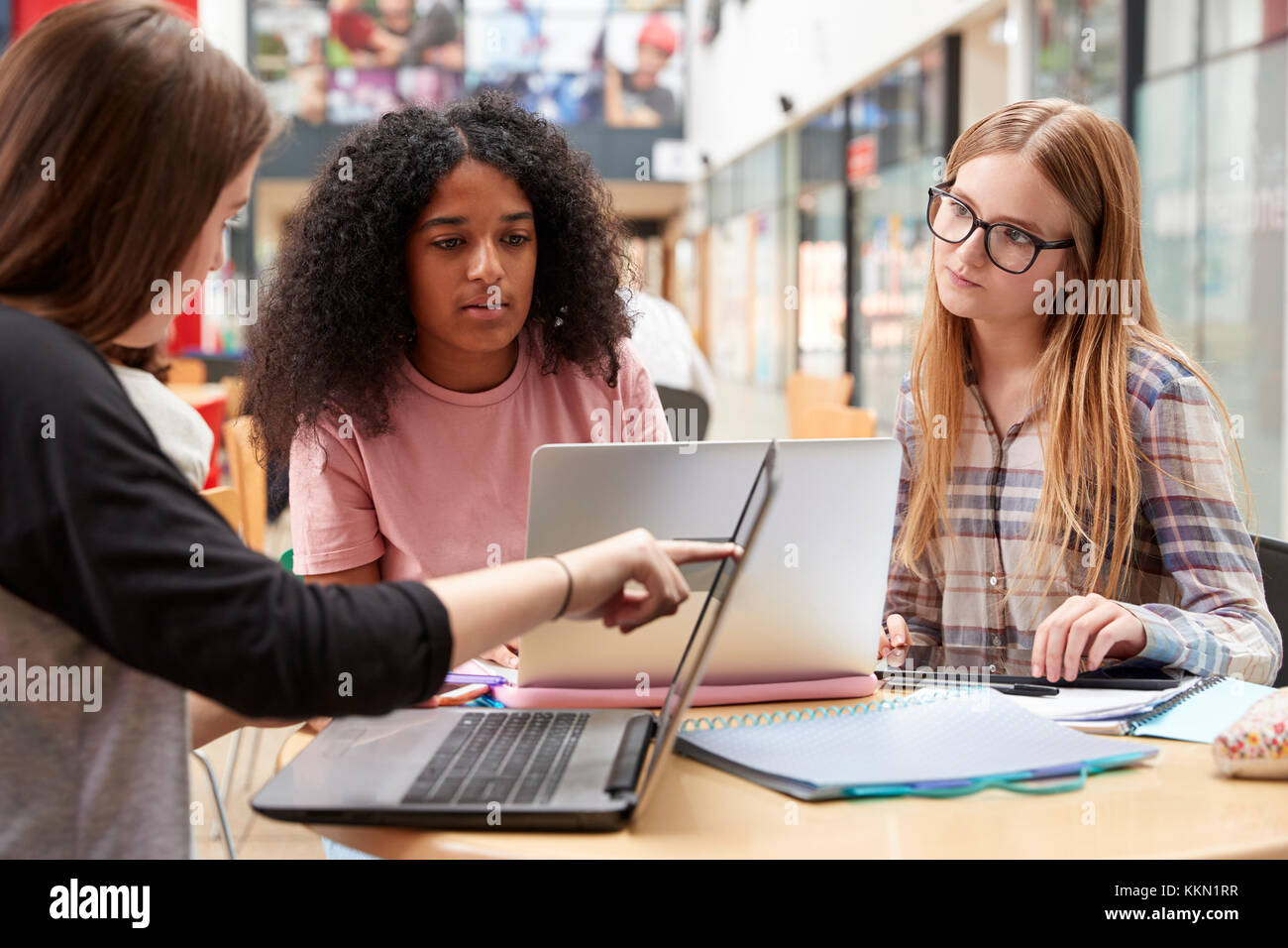 Les élèves de sexe féminin travaillant en zone commune de Busy College Campus Banque D'Images