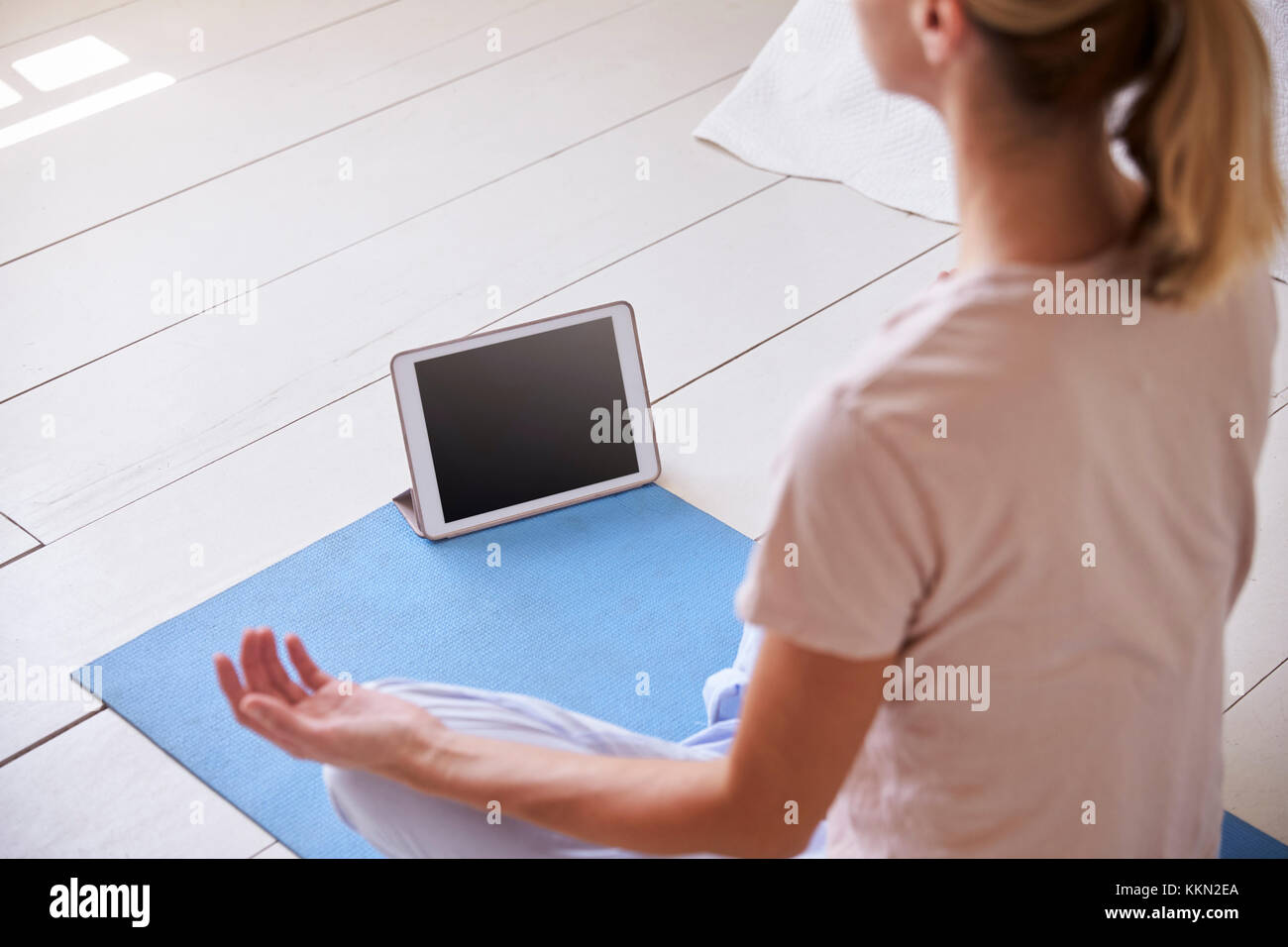 Woman with Digital Tablet App à l'aide de la méditation dans la chambre Banque D'Images