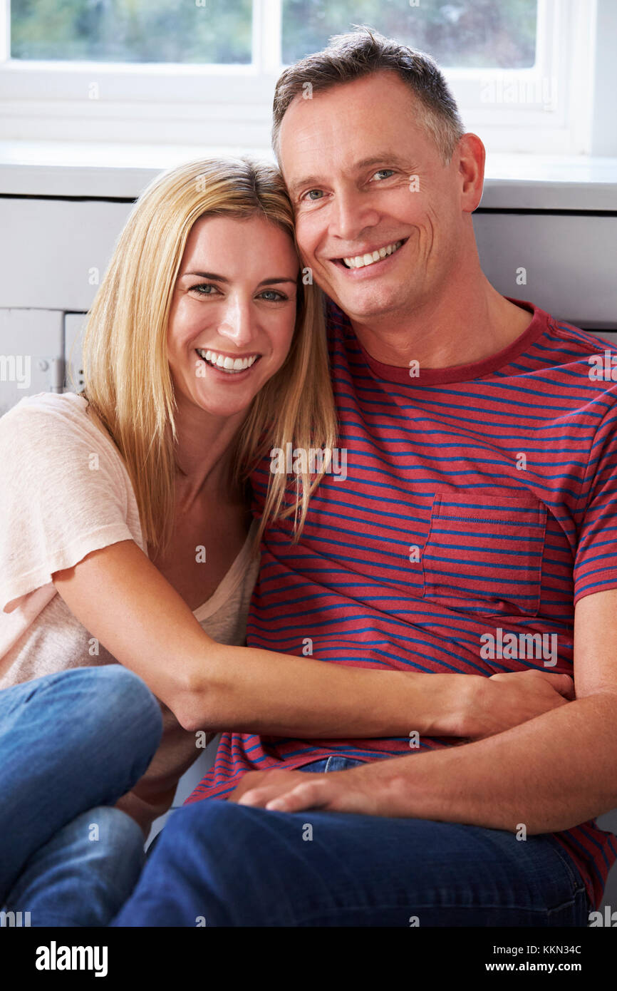 Portrait Of Romantic Couple Relaxing in Chair At Home Banque D'Images