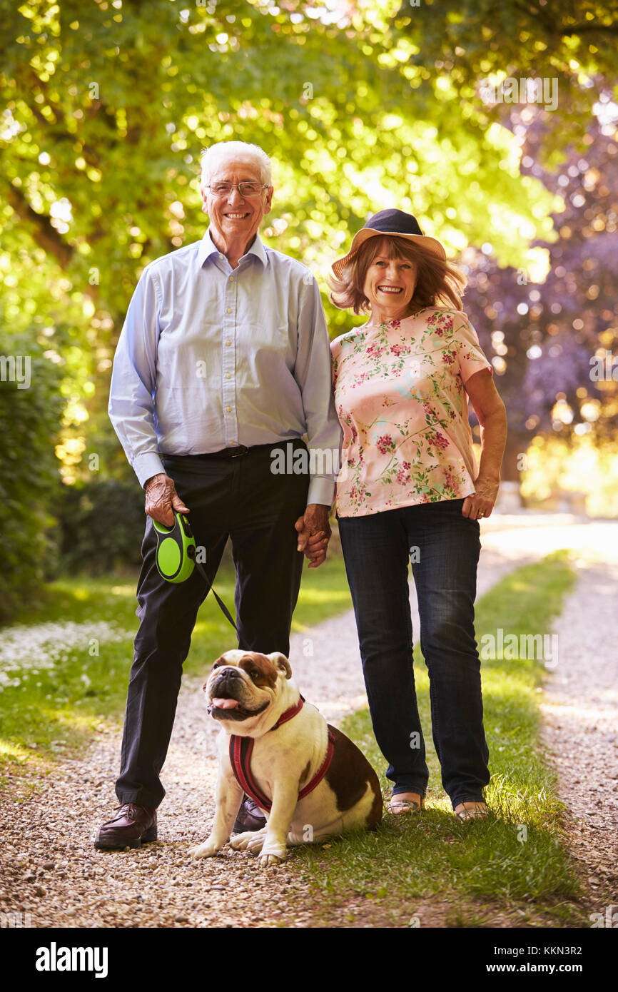 Portrait of Senior Couple Walking Dog Pet In Countryside Banque D'Images