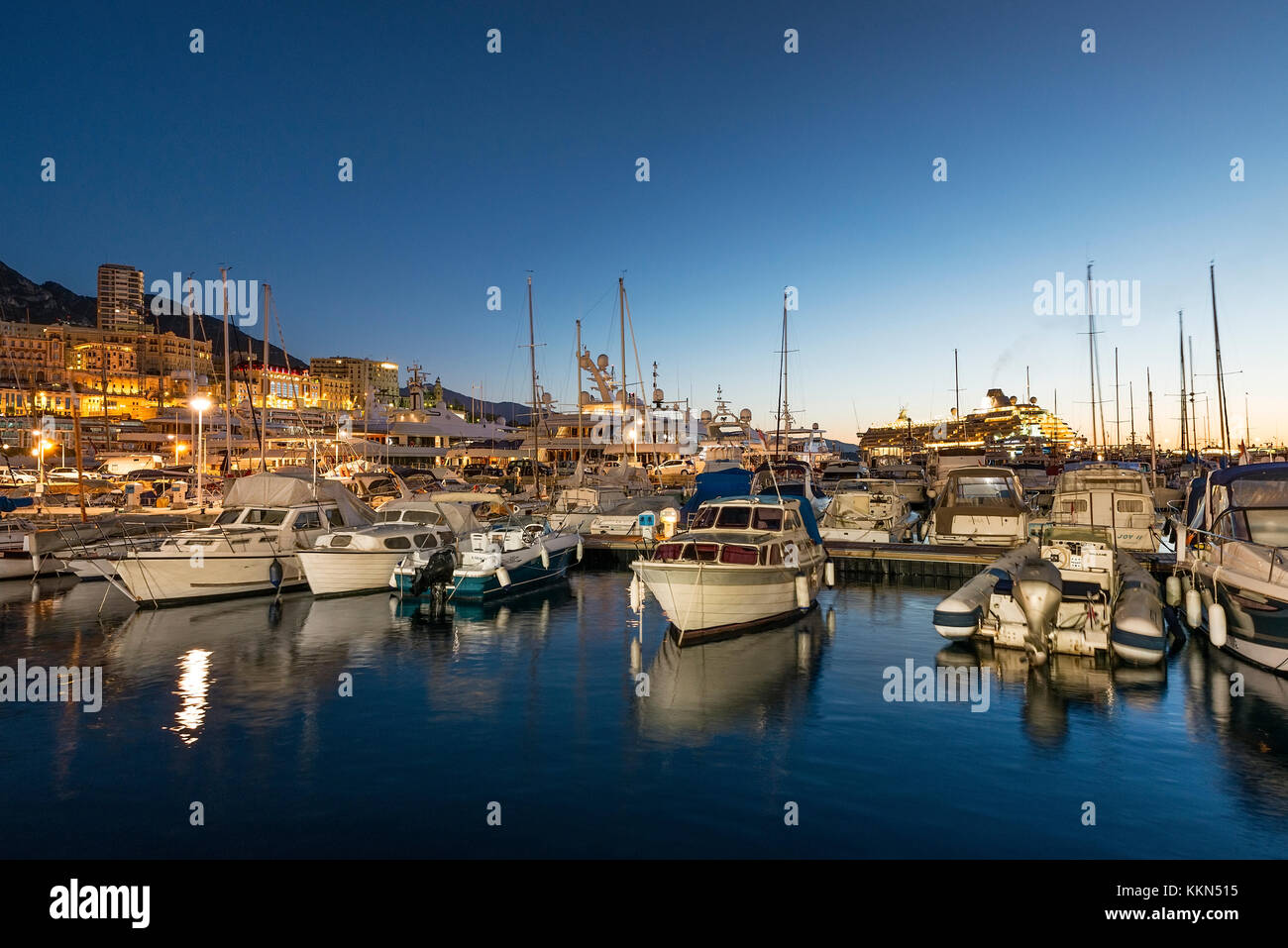 Yachts de plaisance et le centre-ville de Monaco la nuit. Banque D'Images