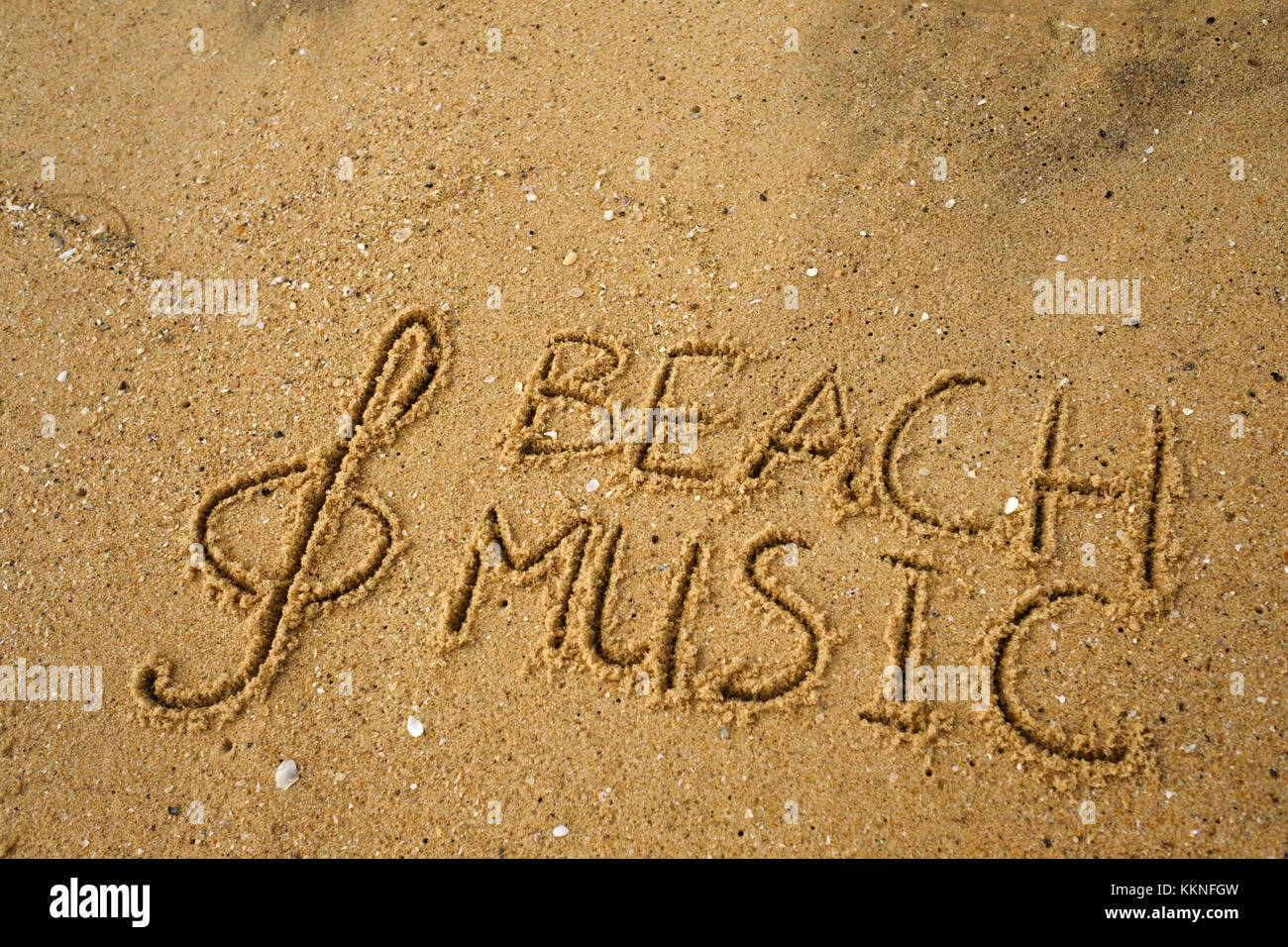 Touche de musique et texte tirés sur une musique de plage de sable. Banque D'Images