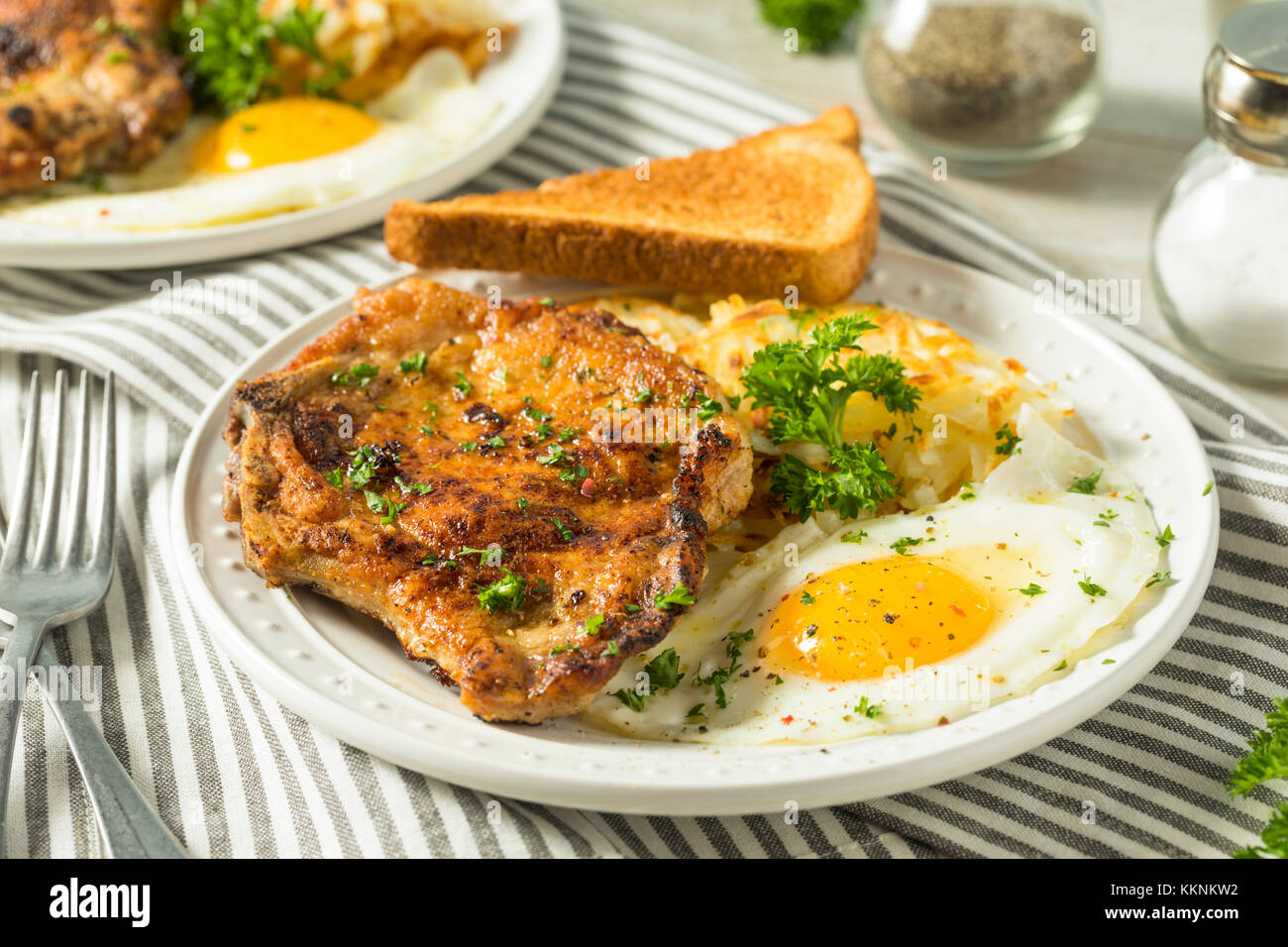 Petit-déjeuner fait maison poêlée de côtelettes de porc aux pommes de terre et oeufs Banque D'Images