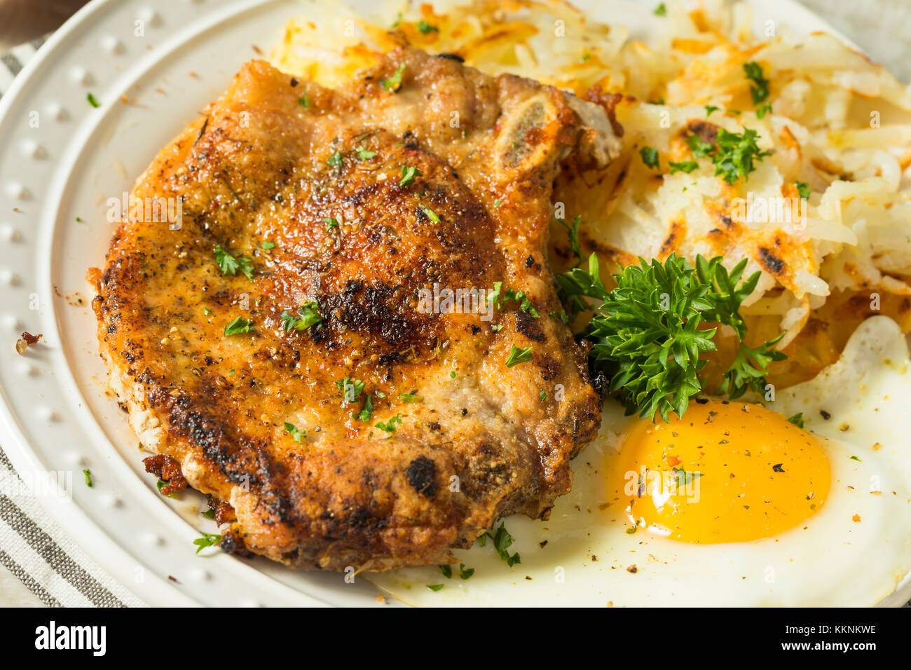 Petit-déjeuner fait maison poêlée de côtelettes de porc aux pommes de terre et oeufs Banque D'Images