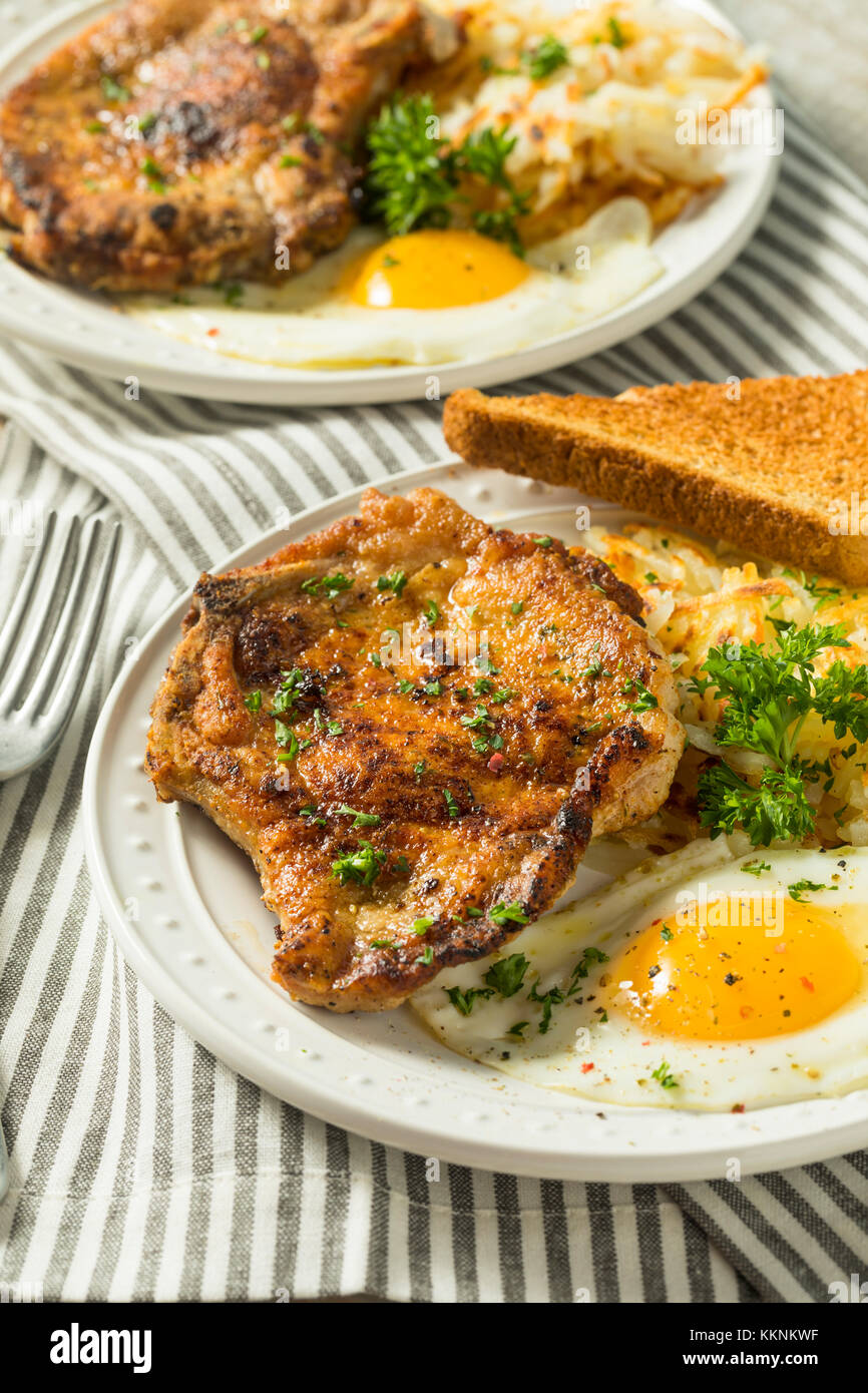 Petit-déjeuner fait maison poêlée de côtelettes de porc aux pommes de terre et oeufs Banque D'Images