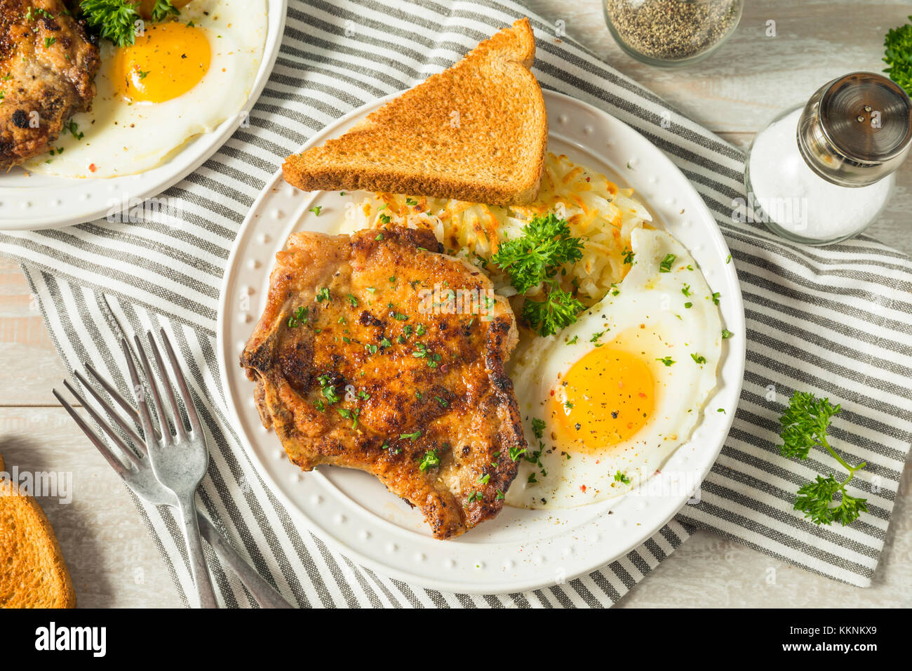 Petit-déjeuner fait maison poêlée de côtelettes de porc aux pommes de terre et oeufs Banque D'Images