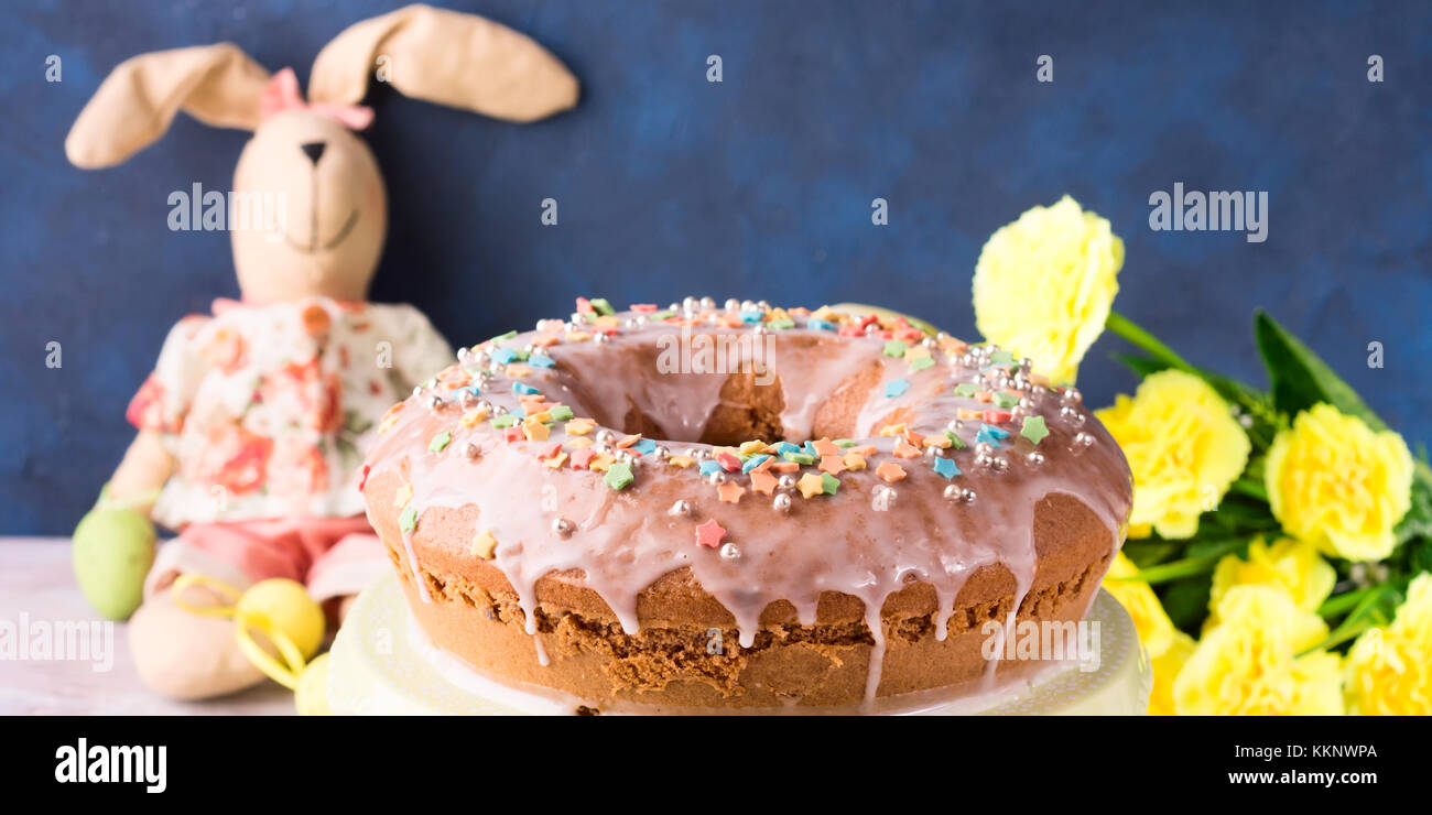 Bundt cake avec anneau de pâques glaçage sucre oeufs décorations sprinkles  et poupée bunny sur fond bleu foncé. fait maison de vacances festives  traiter Photo Stock - Alamy