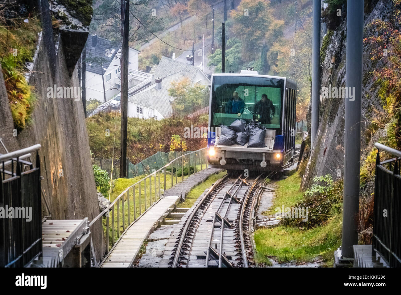 Bergen, Norvège - Octobre 2017 : homme noir de déchargement de sacs remplis de produits d'entretien du funiculaire Floibanen en direction de la station finale Banque D'Images