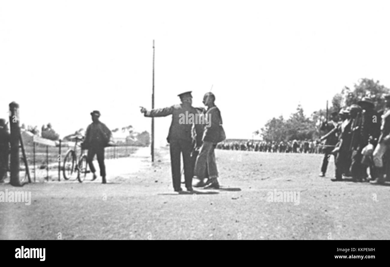 Cette photographie emblématique de 1913 représente Mahatma Gandhi, un dirigeant influent du mouvement indépendantiste indien, dans une interaction tendue avec un policier britannique. Il capture un moment important lors de ses efforts de résistance pacifique. Banque D'Images