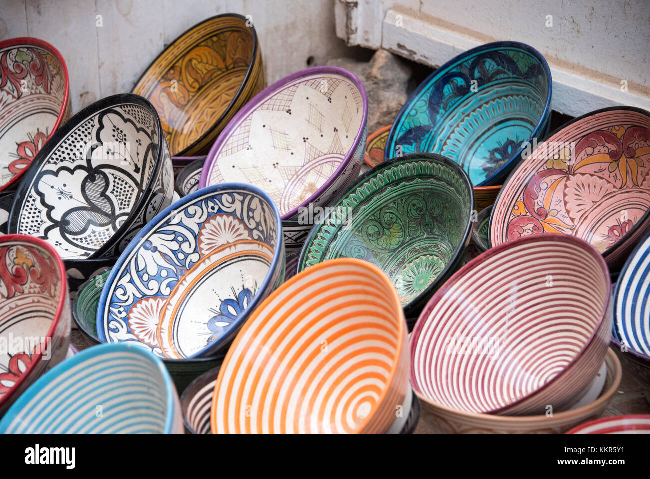 Les plaques colorées et plats traditionnels dans les motifs peints sur la vente dans un marché marocain Banque D'Images