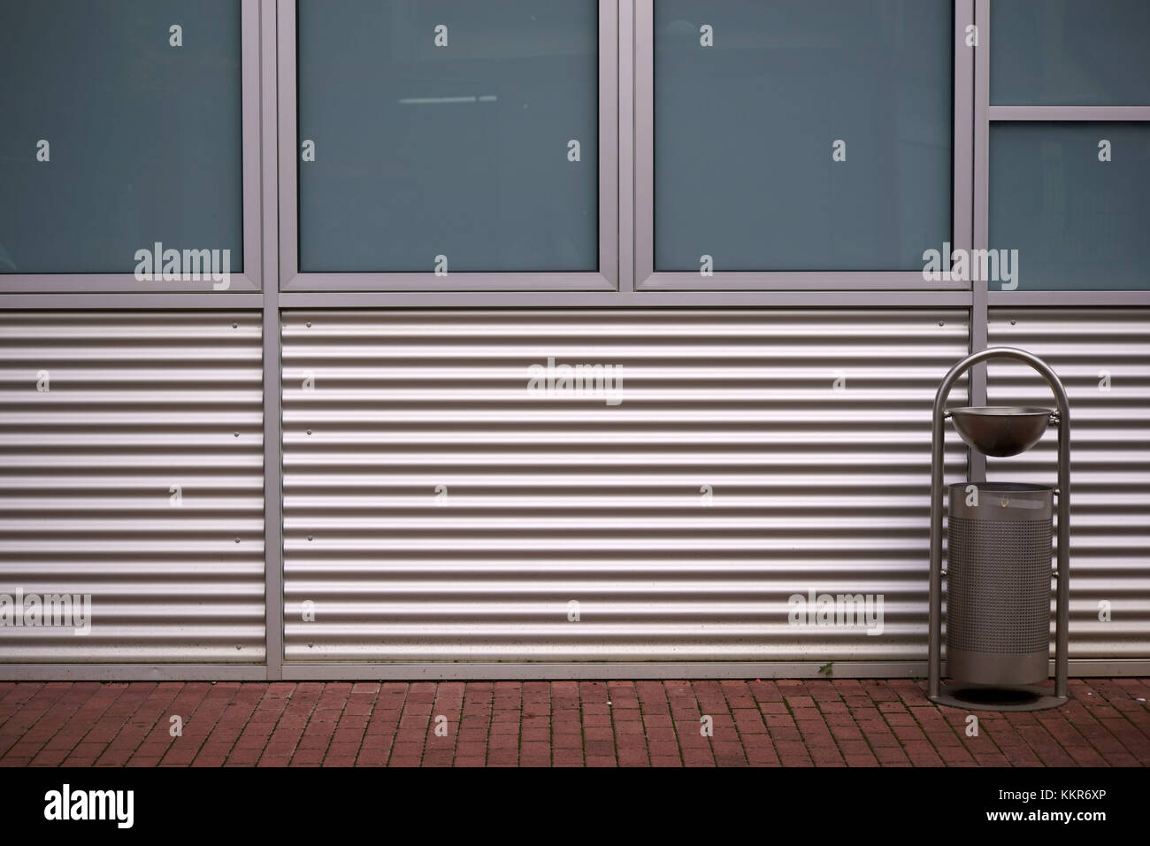 Une poubelle se place en avant d'un bâtiment moderne couverte en tôle Banque D'Images