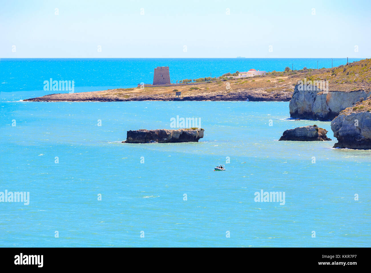 Calalunga Tower avec un petit bateau amarré entre les rochers. Pouilles, Manaccora(Puglia, Italie. Banque D'Images