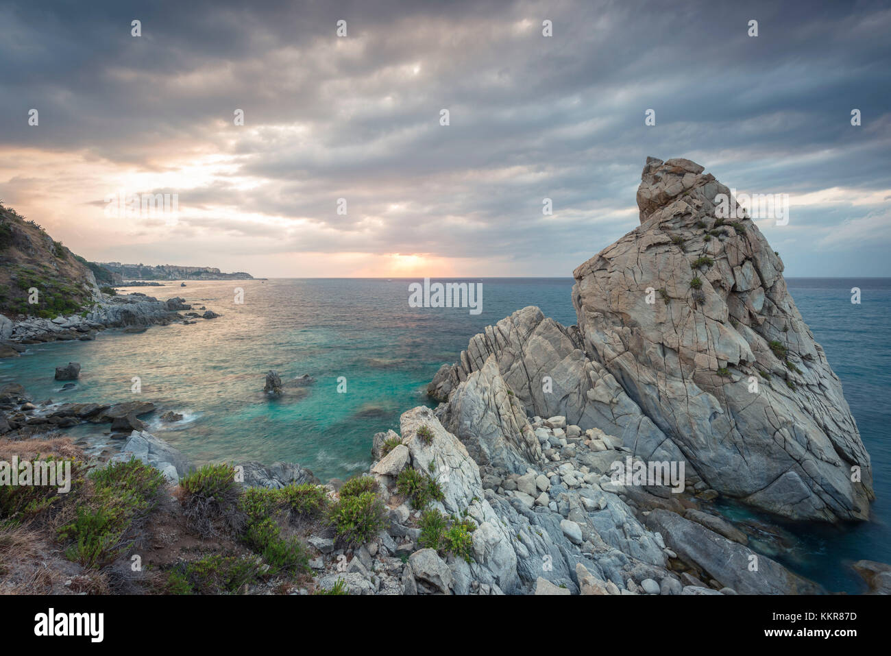 Tropea, province de Vibo Valentia, Calabre, Italie. Vue panoramique sur le Scoglio della Pizzuta en direction de Tropea au coucher du soleil. Banque D'Images