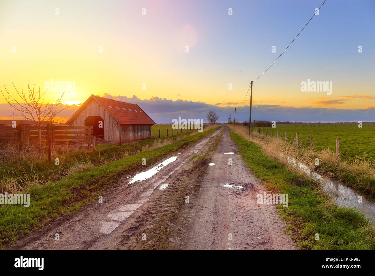 Une grange en Frise orientale au coucher du soleil Banque D'Images