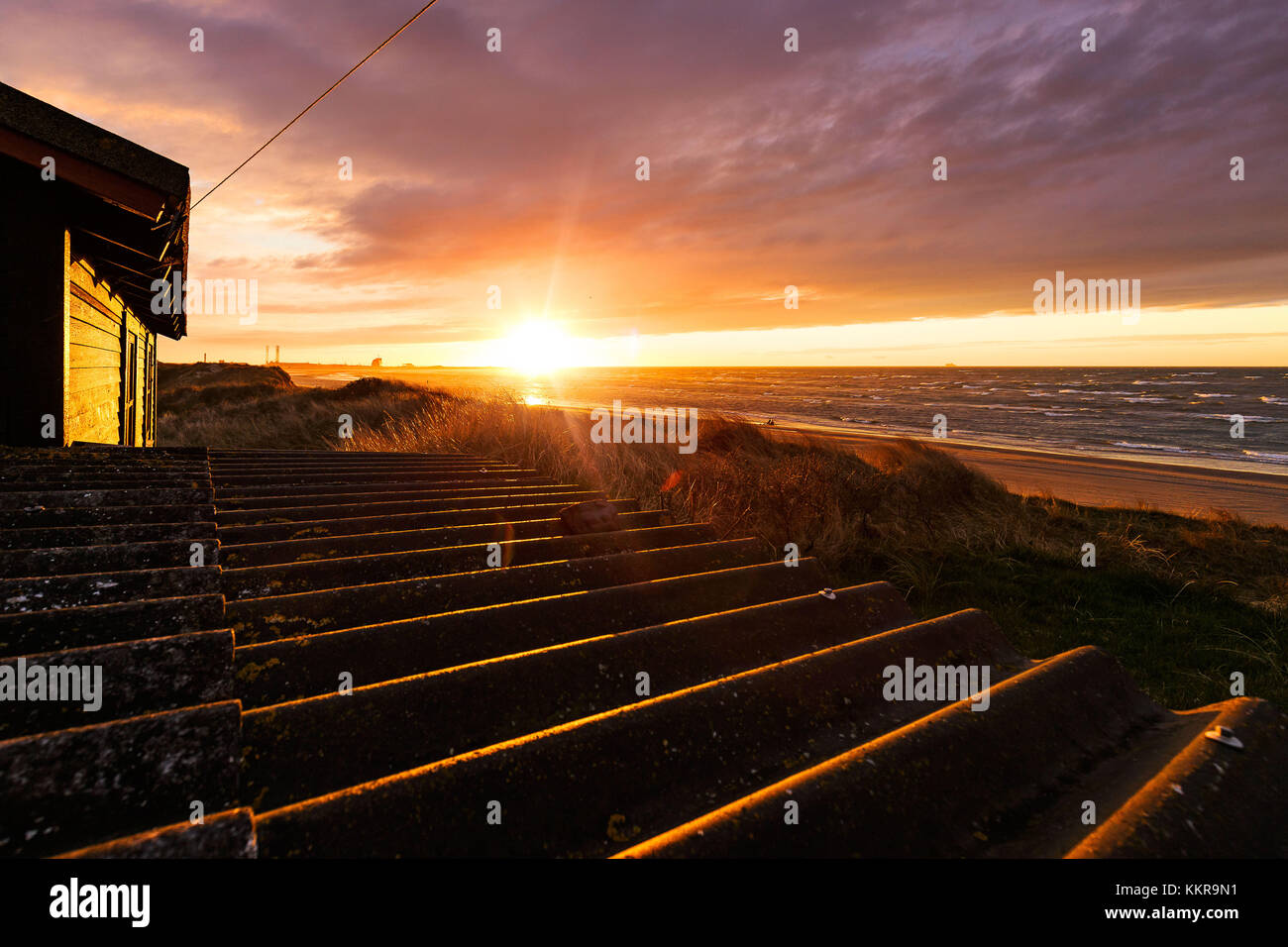 Maison dans les dunes au coucher du soleil sur une plage près de Hirtshals. Banque D'Images