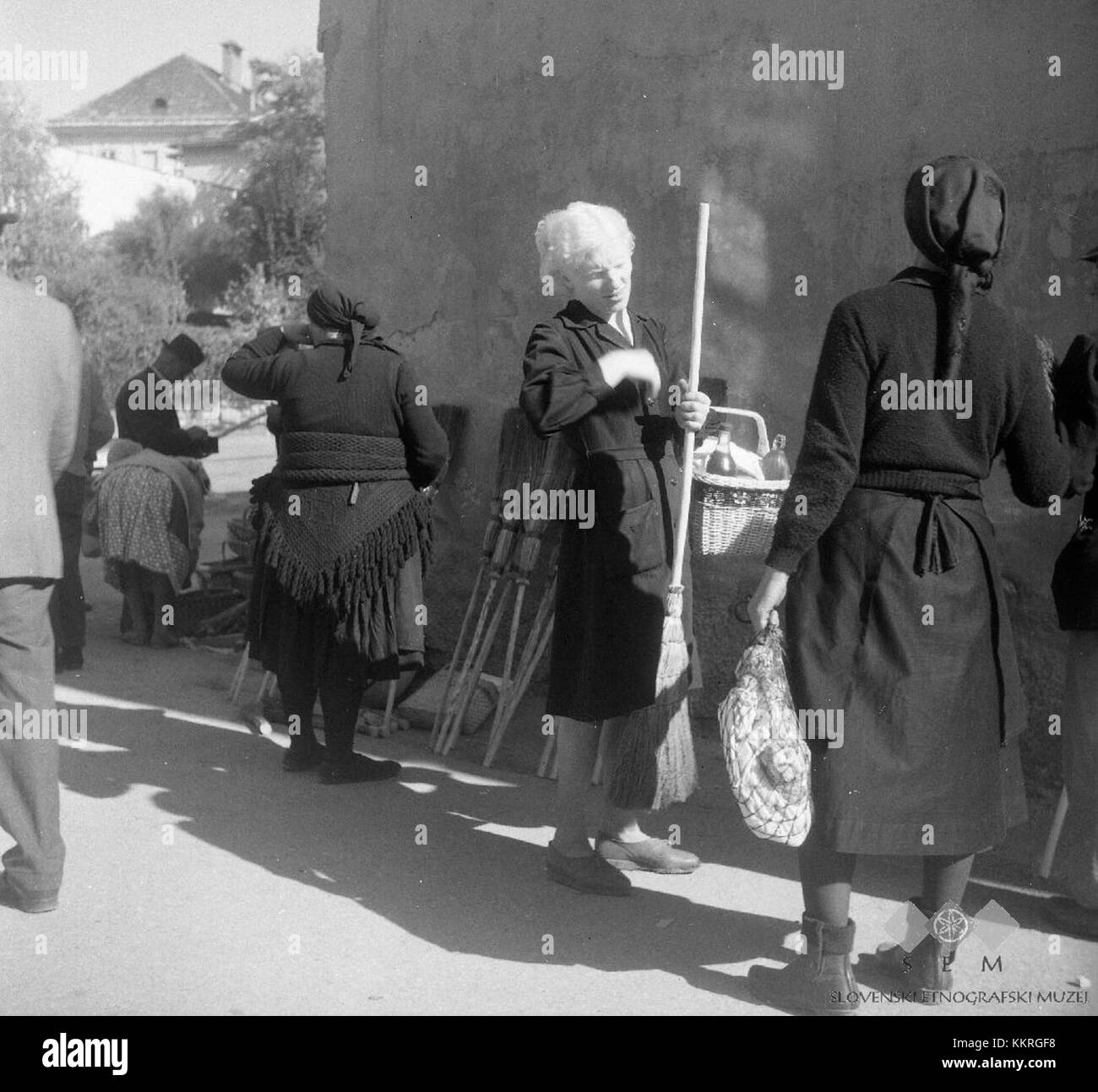 Photographies de la foire de Metlika, en Slovénie, 1965, capturant les vêtements traditionnels slovènes, l'artisanat et les pratiques culturelles, y compris des scènes de vendeurs vendant des produits faits main et des visiteurs s'entretenant avec des artisans locaux. Banque D'Images