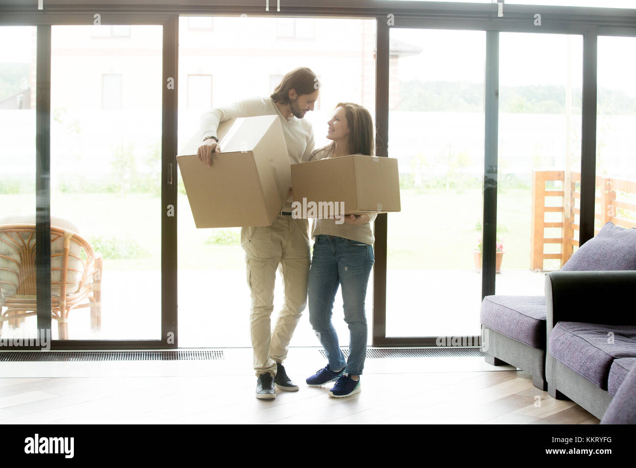 Couple heureux propriétaires chargés de boîtes dans de nouveaux pays h Banque D'Images