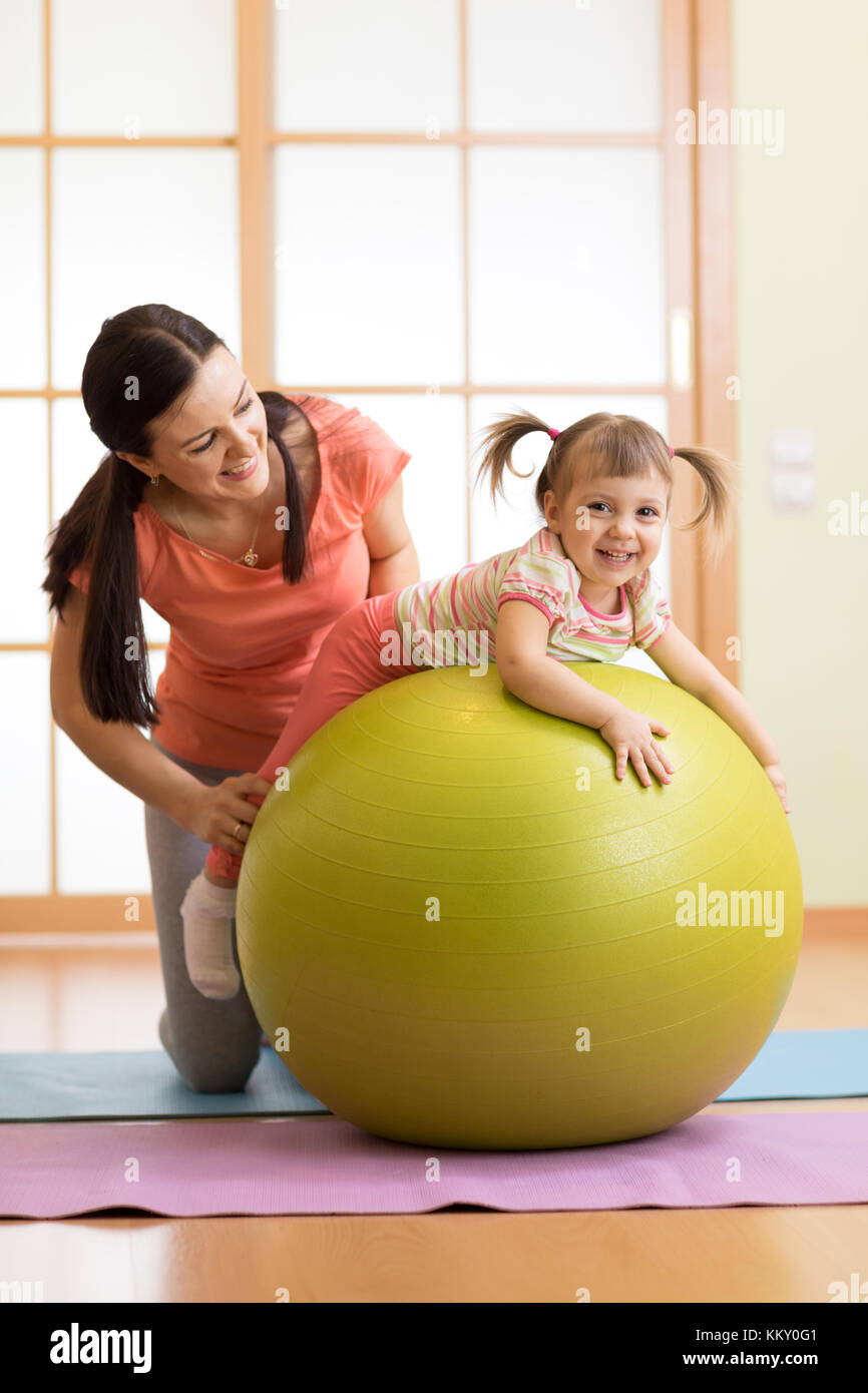 Mère avec childdoing exercices avec ballon de gymnastique à la maison. concept de prendre soin de la santé du bébé. Banque D'Images