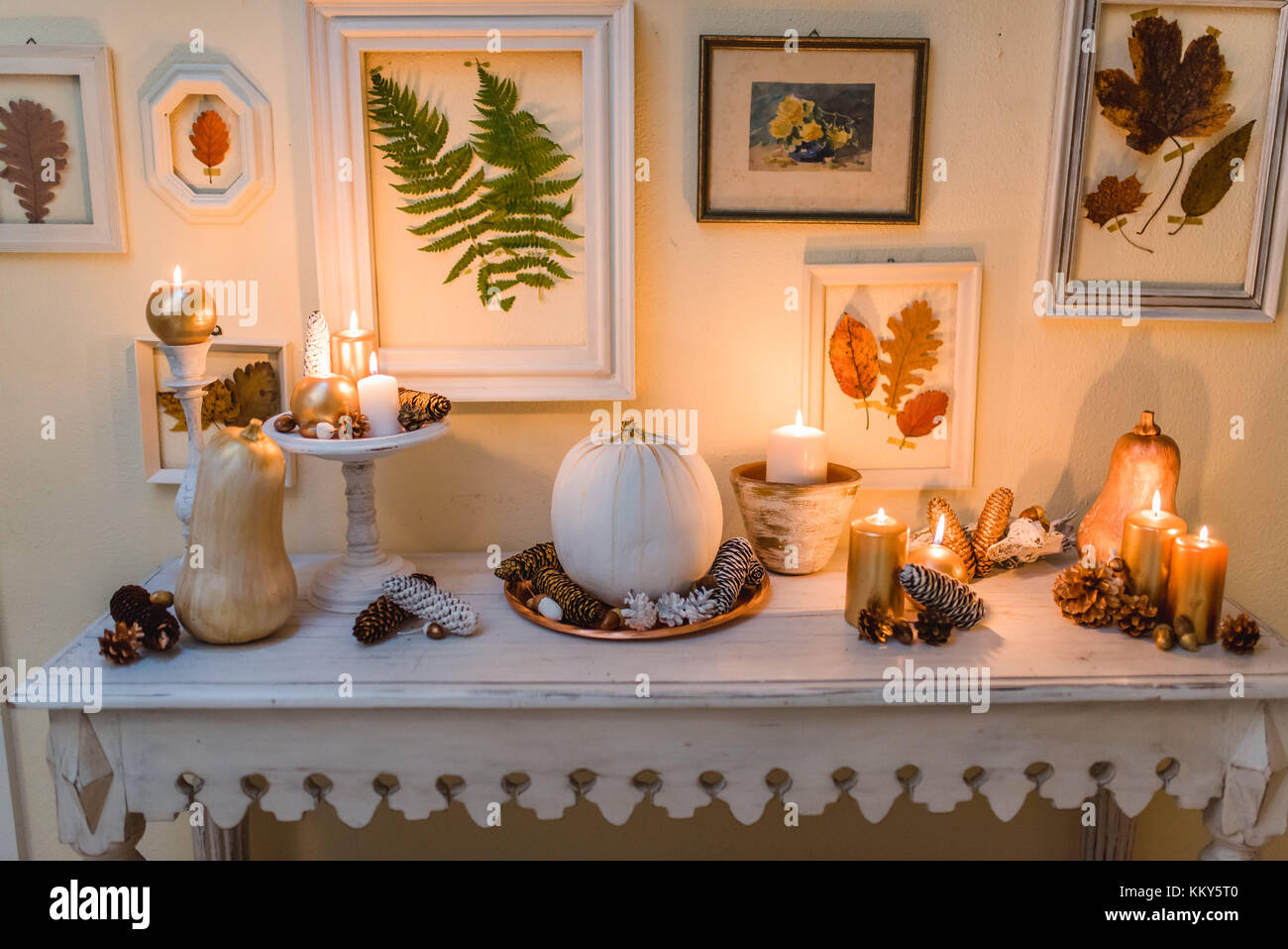 Table console, décoration d'automne, des bougies, des cadres photo, des feuilles Banque D'Images