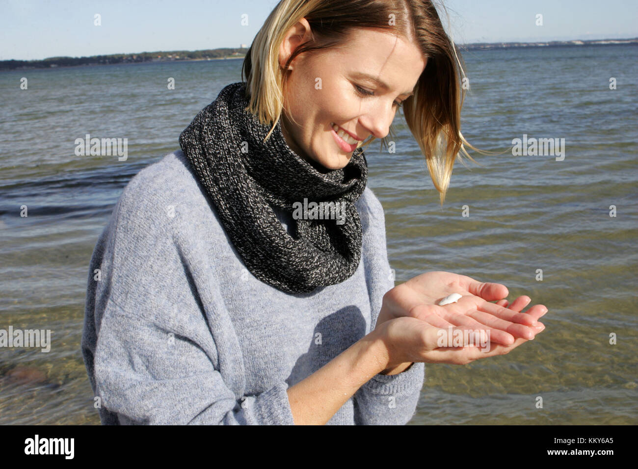 Femme, blonde, mer baltique, loisirs, ramasser des coquillages sur la plage Banque D'Images