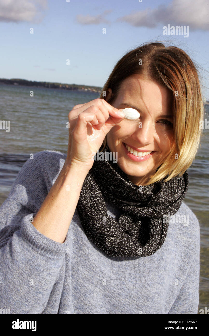 Femme, blonde, mer baltique, loisirs, ramasser des coquillages sur la plage Banque D'Images