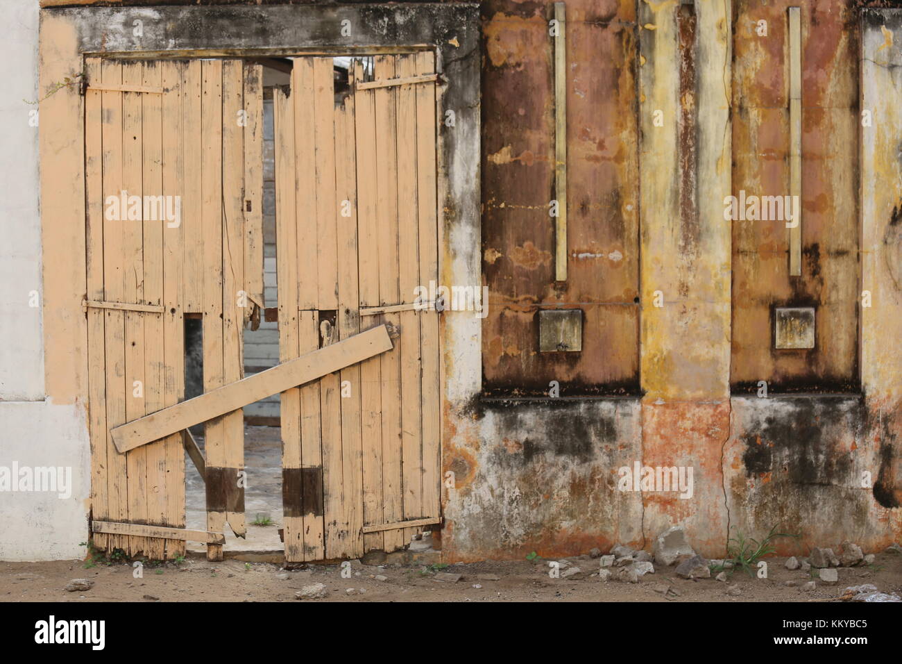 Détail d'un vieux mur avec une porte en bois fermée à Grand Bassam en Côte d'ivoire Banque D'Images