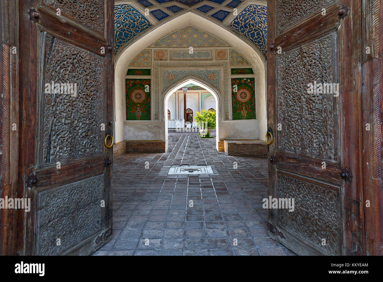 Ancien palais de Khudayar à travers ses portes en bois, dans la région de Kokand, Ouzbékistan. Banque D'Images