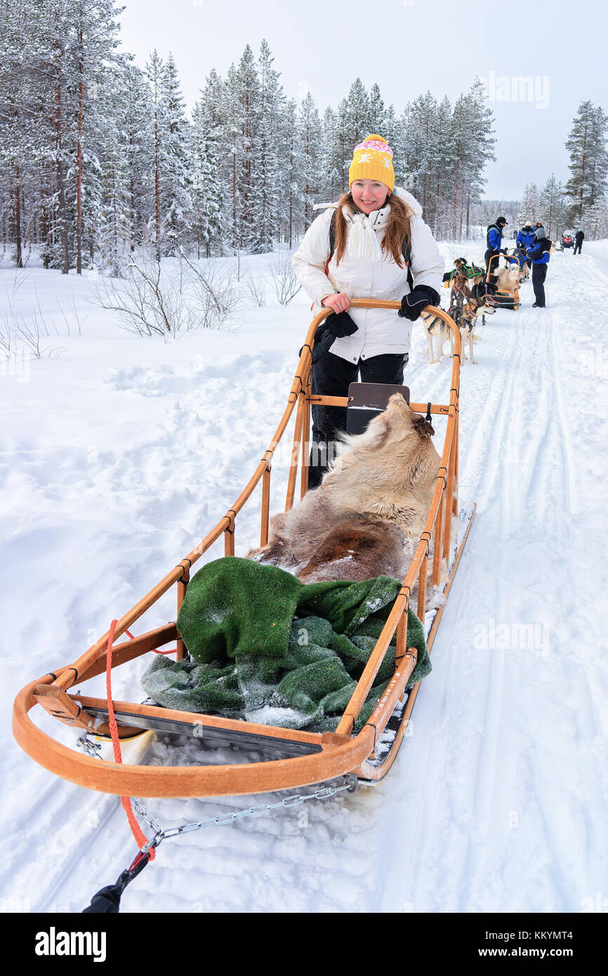 Woman riding en traîneau à chiens husky à Rovaniemi, forêt en hiver en Finlande, Laponie Banque D'Images