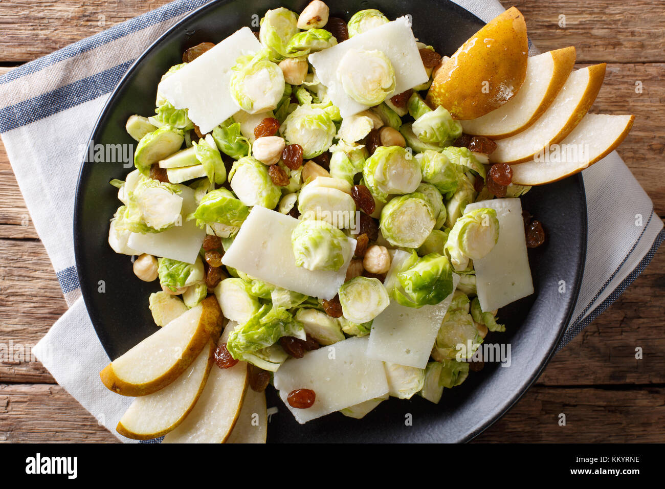 Salade de choux de bruxelles organique avec les noisettes, fromage, raisins et poires libre sur une plaque horizontale. haut Vue de dessus Banque D'Images