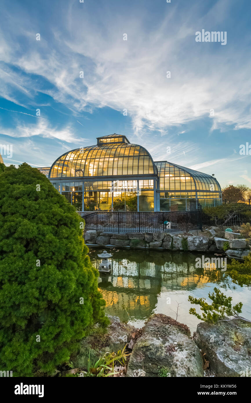 Vue extérieure, à partir de l'étang aux nénuphars, d'greenouses par rétro-éclairé le soleil couchant à l'anna scripps whitcomb conservatory à belle isle park, Détroit, mic Banque D'Images