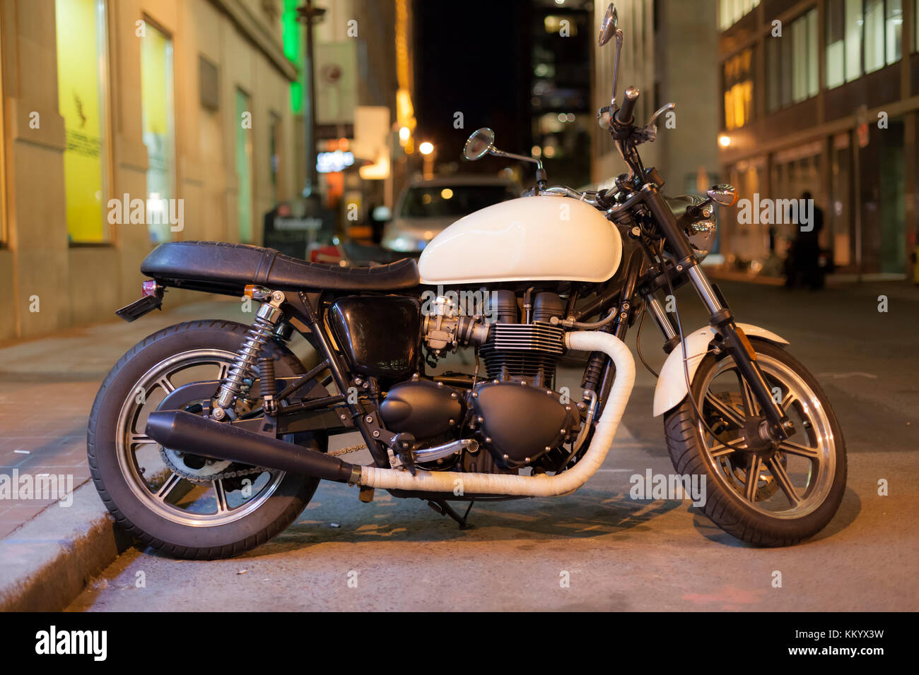 Moto classique stationné dans une rue de la ville la nuit Banque D'Images