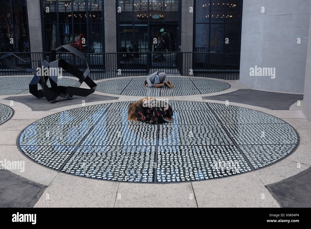 Une jeune femme regarde vers le bas à travers un plancher de verre sur le toit de la Zeitz Musée d'Art moderne contemporain en Afrique Le Cap, Afrique du Sud Banque D'Images