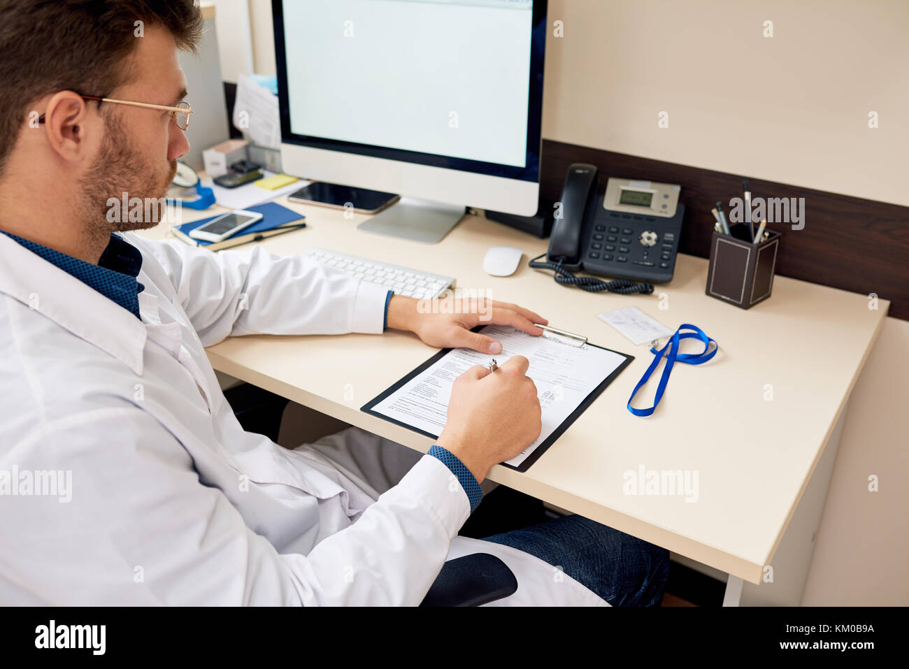 Doctor Working at Desk in Office Banque D'Images