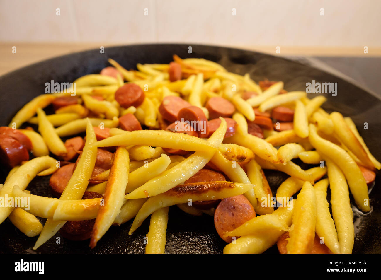 Close-up boulettes de pommes de terre et debreziner saucisses à la poêle en fonte Banque D'Images