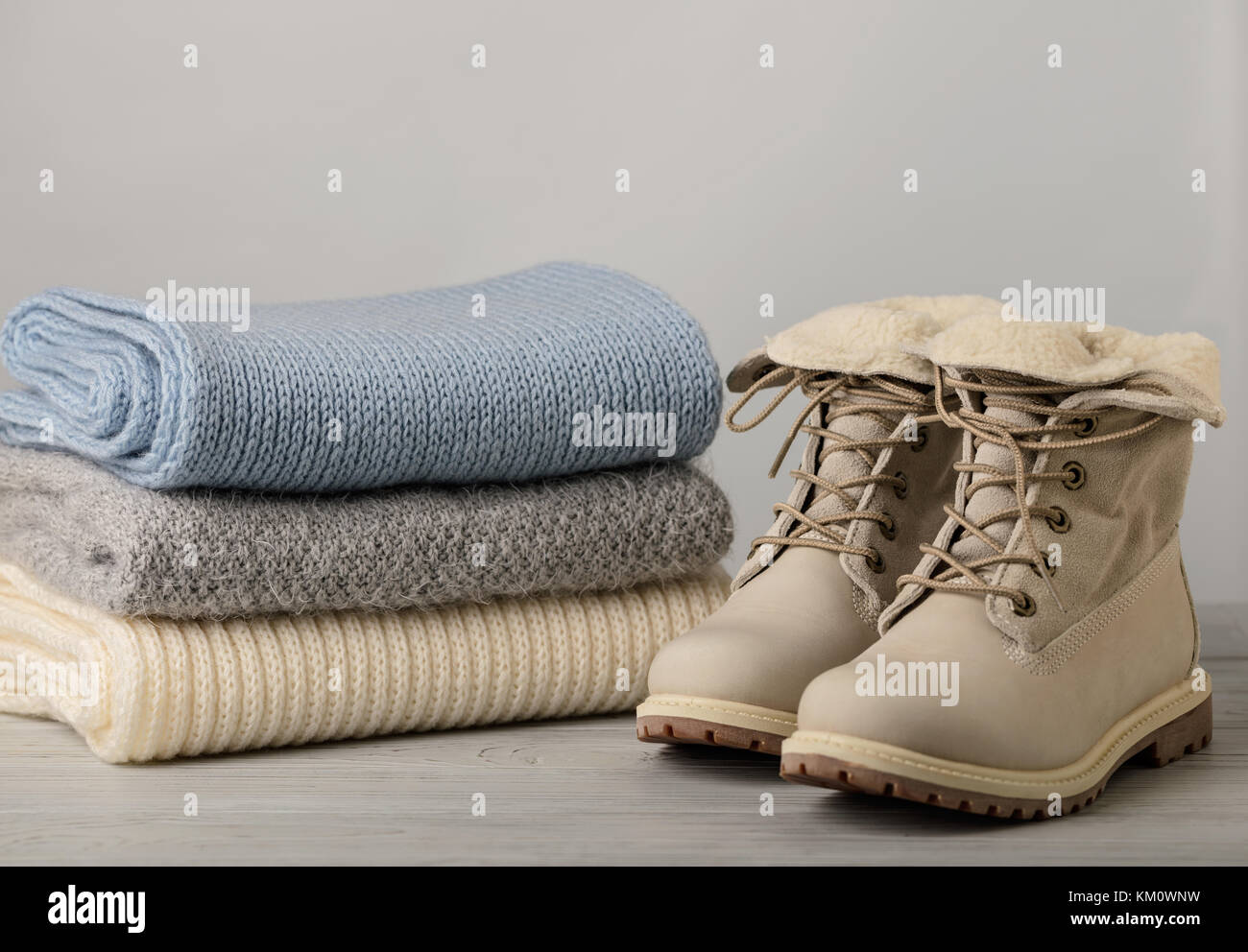 La lumière de la femme en cuir les bottes d'hiver et un tas de choses en tricot (pulls, écharpes, gants). focus sélectif. Banque D'Images