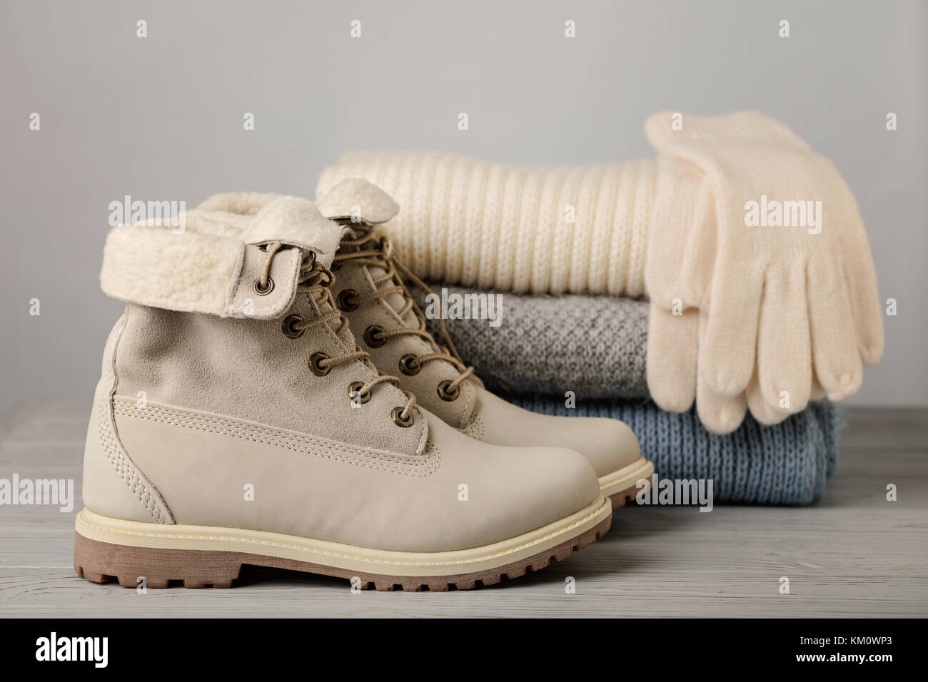 La lumière de la femme en cuir les bottes d'hiver et un tas de choses en tricot (pulls, écharpes, gants). focus sélectif. Banque D'Images