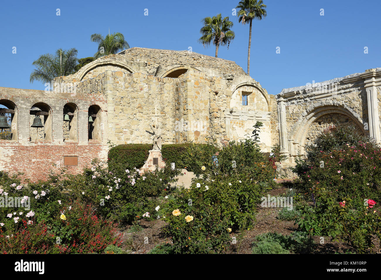San Juan Capistrano, CA - décembre 1, 2017 Mission : clocher-mur et Serra Statue avec les ruines de la grande église de pierre. Banque D'Images