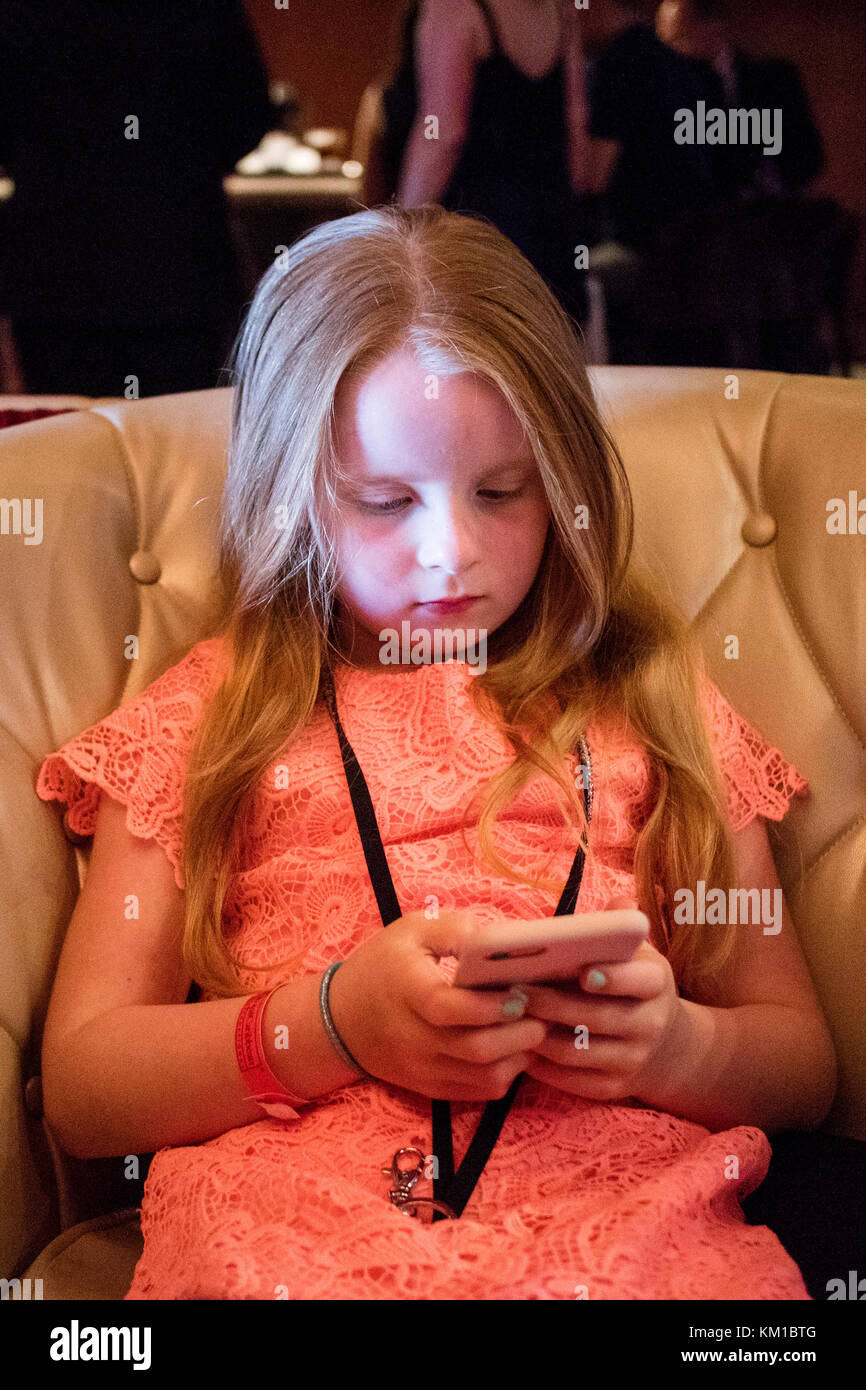 7 ans, fille de jouer sur son iphone Banque D'Images
