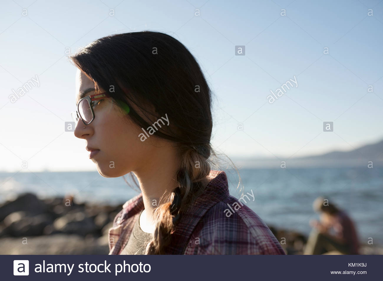 Sérieux, pensive brunette woman braid sur sunny beach océan Banque D'Images