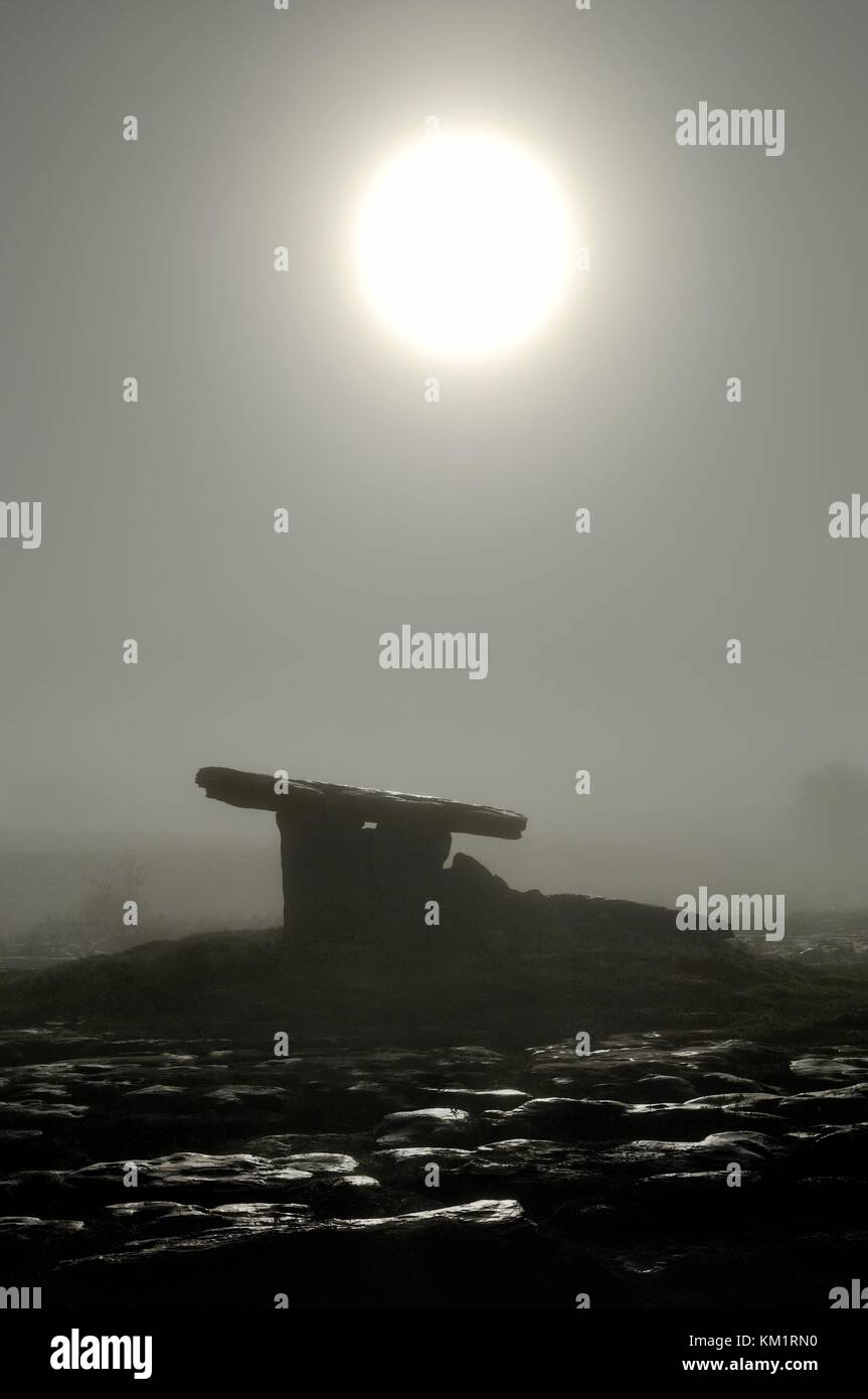 Lever de lune dans le brouillard sur l'âge de pierre préhistoriques de poulnabrone dolmen tombe. le plateau calcaire du Burren, comté de Clare, Irlande Banque D'Images