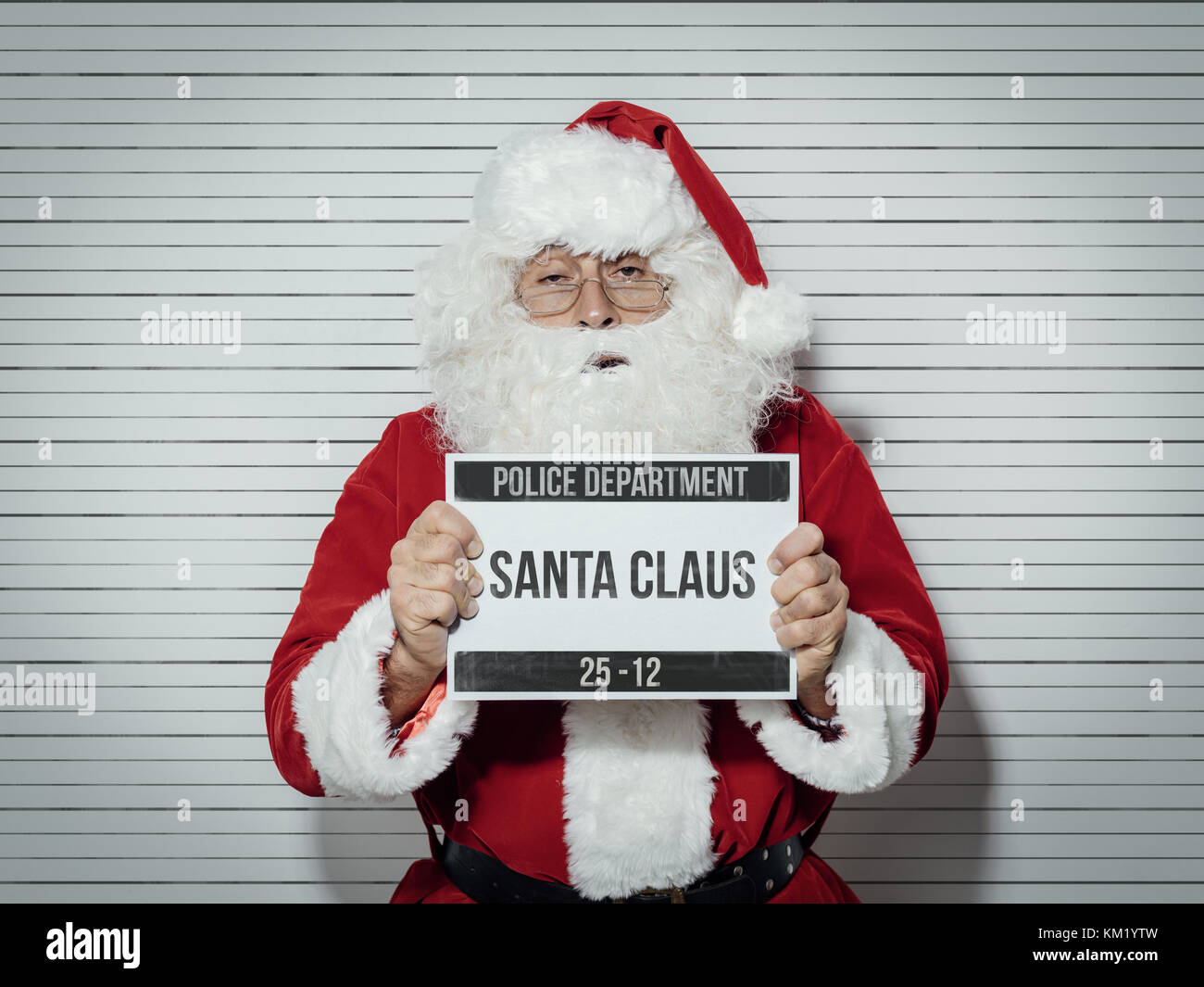 Santa Claus arrêtés la veille de Noël, il est posé pour son mug shot au département de la police et la tenue d'un conseil d'identification Banque D'Images