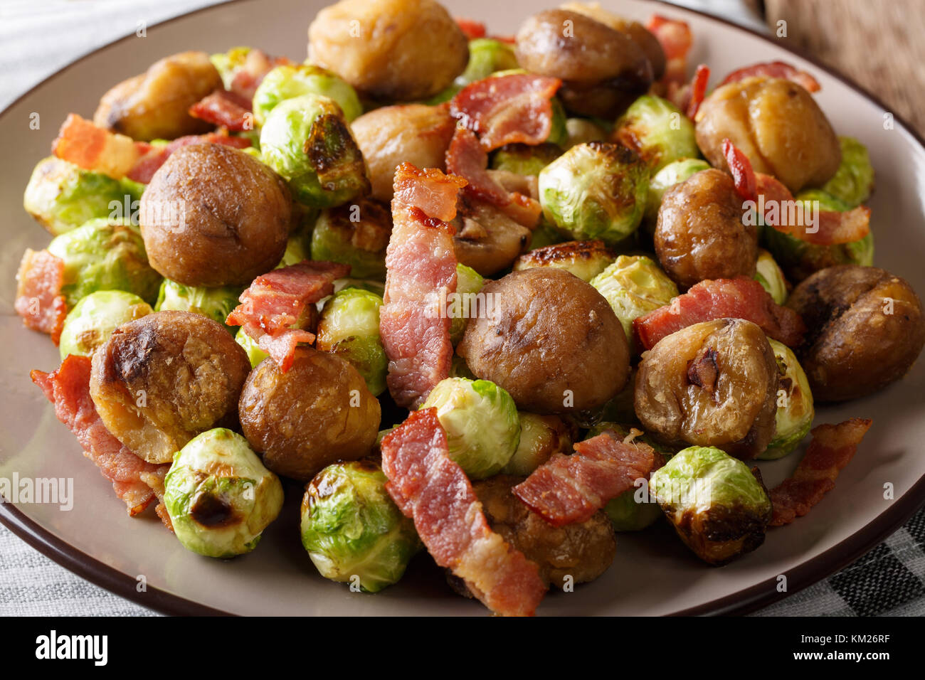 Délicieuse salade de châtaignes, chou de Bruxelles et le bacon sur une assiette horizontale. Banque D'Images