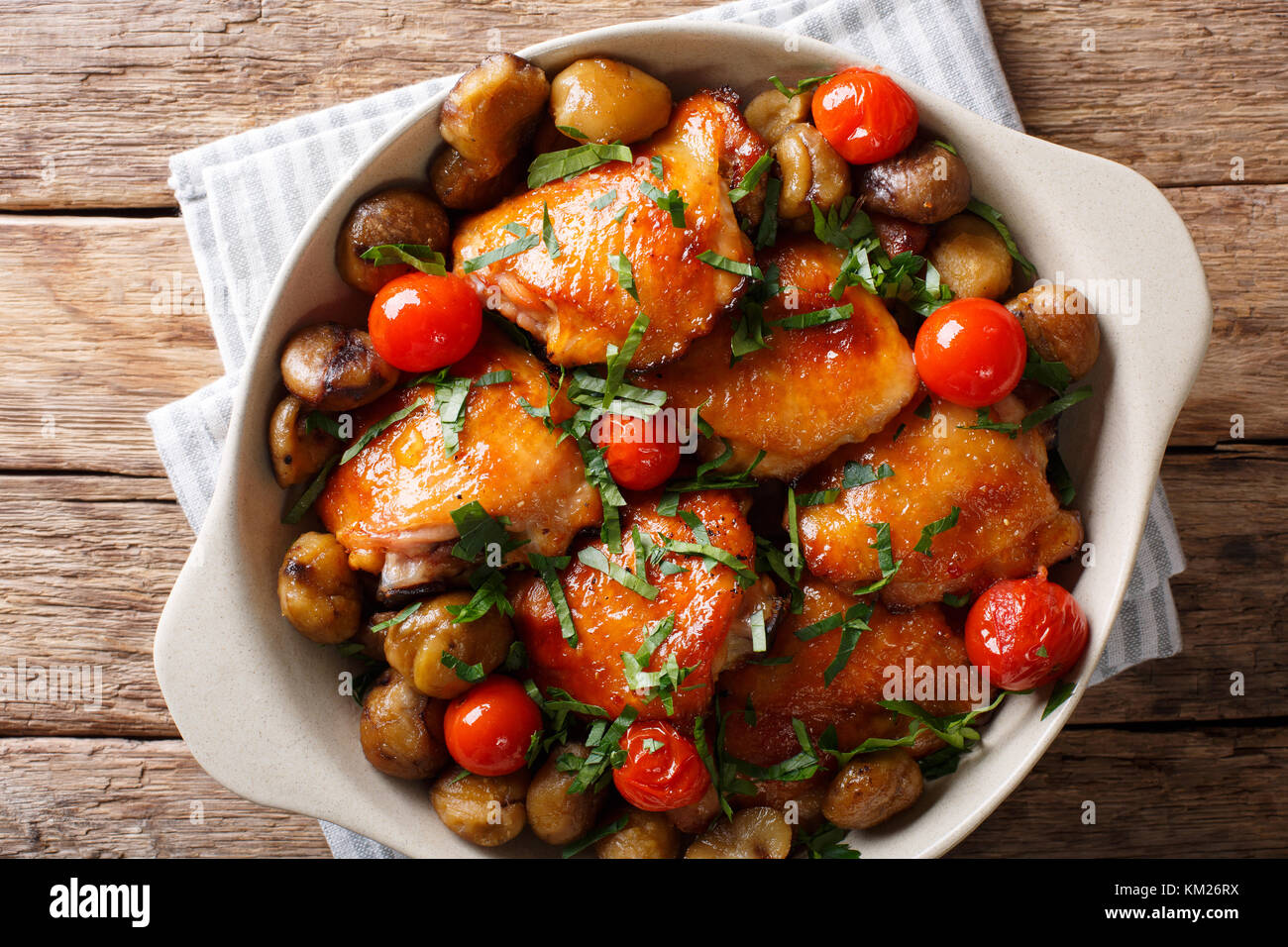Poulet frit aux châtaignes, verts et tomates close-up dans un bol sur la table. haut horizontale Vue de dessus Banque D'Images