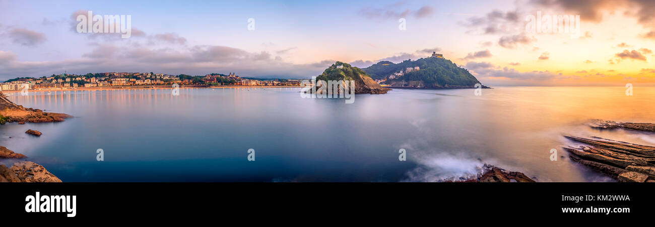 La célèbre baie de La Concha au coucher du soleil avec le Monte Igueldo sur la droite, l'île de Santa Clara dans le centre et la ville de San Sebastian sur la gauche. Banque D'Images