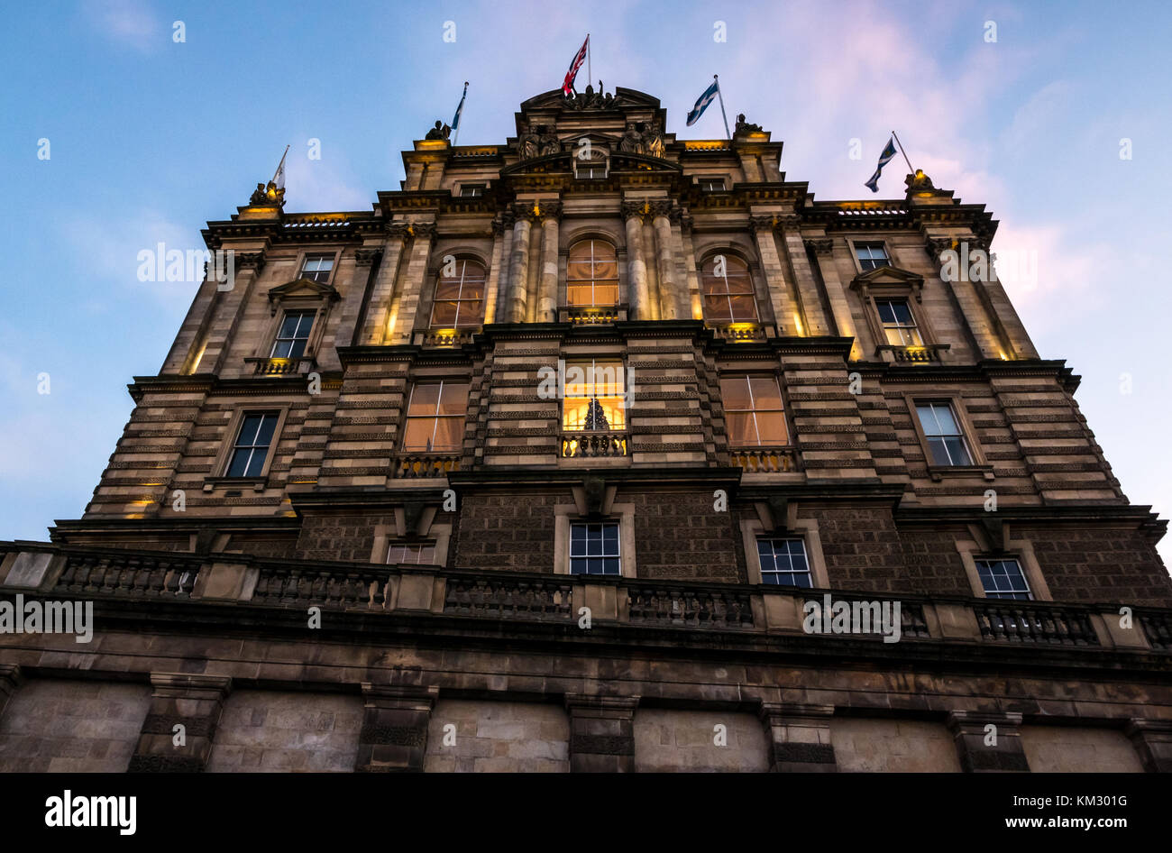 Bâtiment victorien Bank of Scotland, la butte de l'administration centrale, illuminée au crépuscule avec arbre de Noël dans la fenêtre et drapeaux au vent, Édimbourg, Écosse, Royaume-Uni Banque D'Images